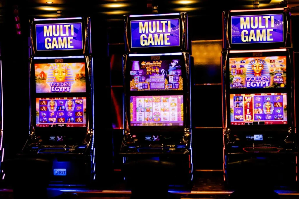 Trois machines à sous IGT Multi Game avec les jeux Golden Egypt et Stinkin Rich sur les écrans.